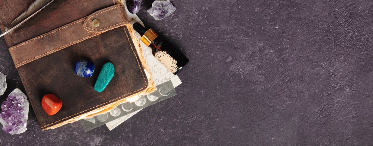 Leather journal with healing crystals, sage and a candle