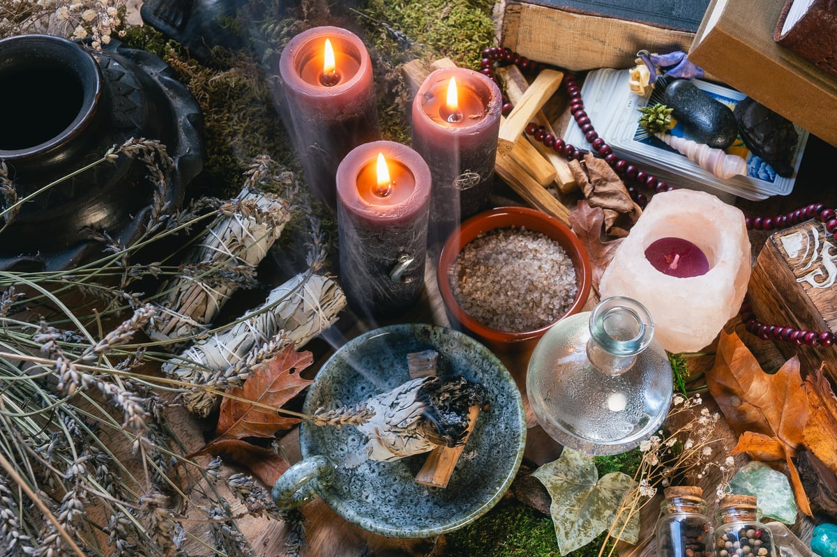 Altar with burning candles, crystals and ritual herbs
